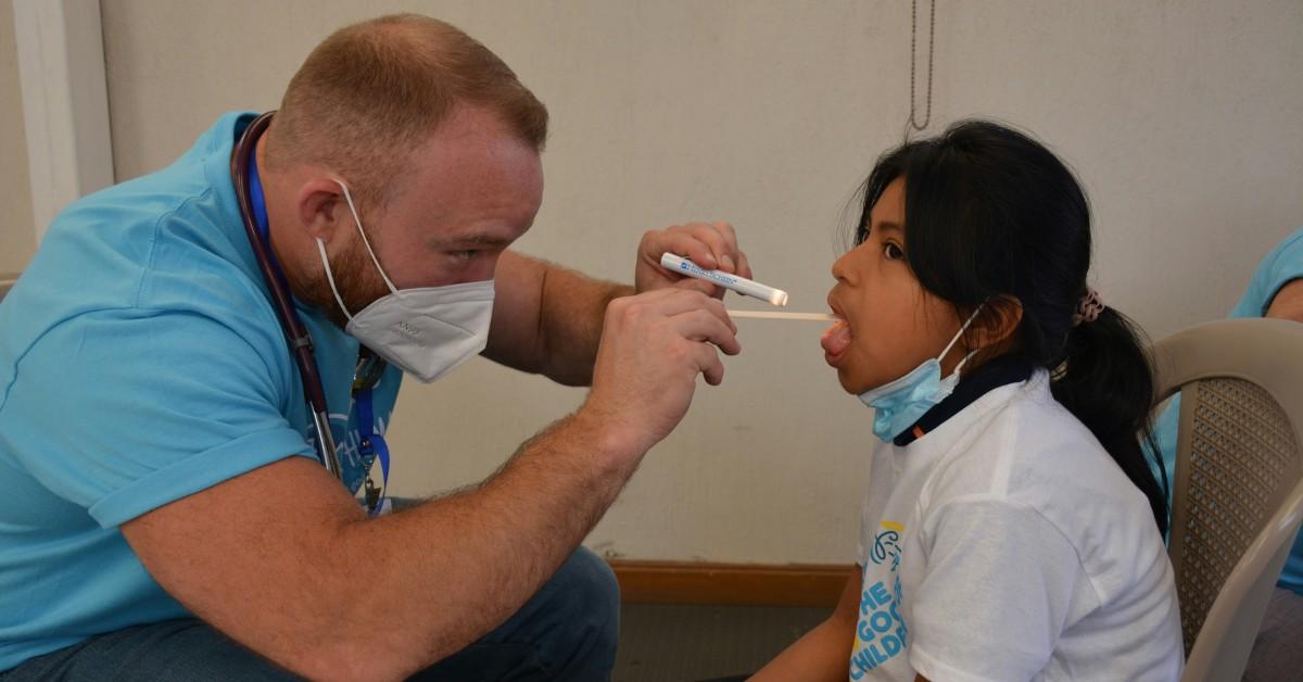 A doctor examines a woman's throat