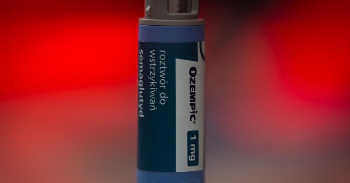 A 1mg Ozempic injection tube in front of a glowing red background. 