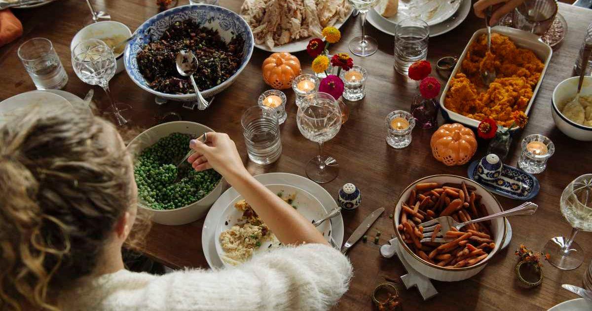 An individual sits at the dinner table filled with Thanksgiving delicacies. (Representative Cover Image Source: Getty Images | The Good Brigade)