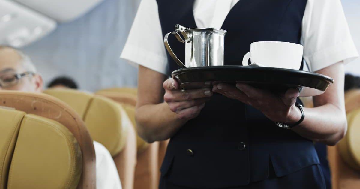 The flight attendant holds a tray with a cup of coffee. (Representative Cover Image Source: Getty Images | Thomas Barwick)