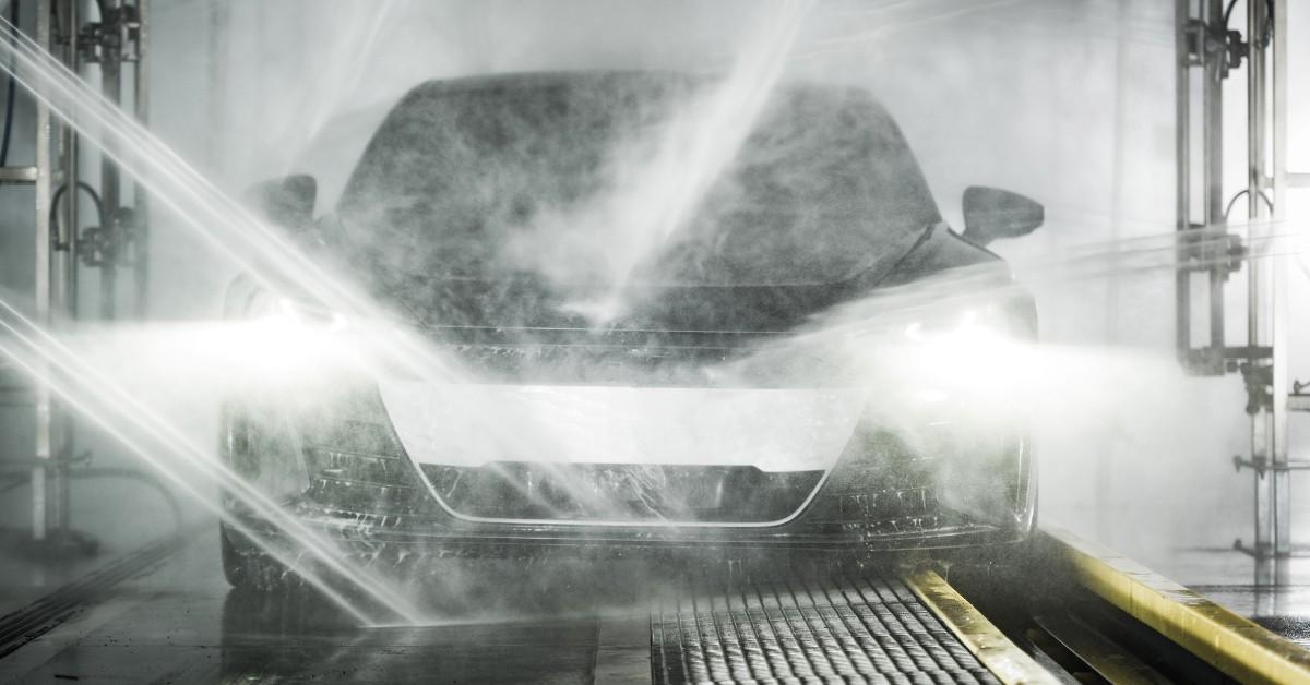 Hoses spray a car down inside a car wash