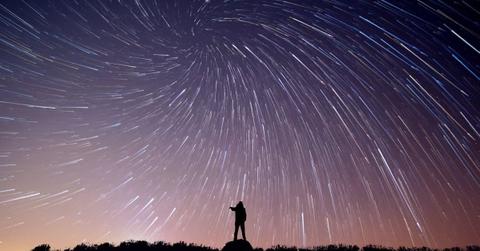 Silhouette of a person standing under a sky filled with shooting stars (Representative Cover Image Source: Getty Images | Eyem Mobile GMPH)