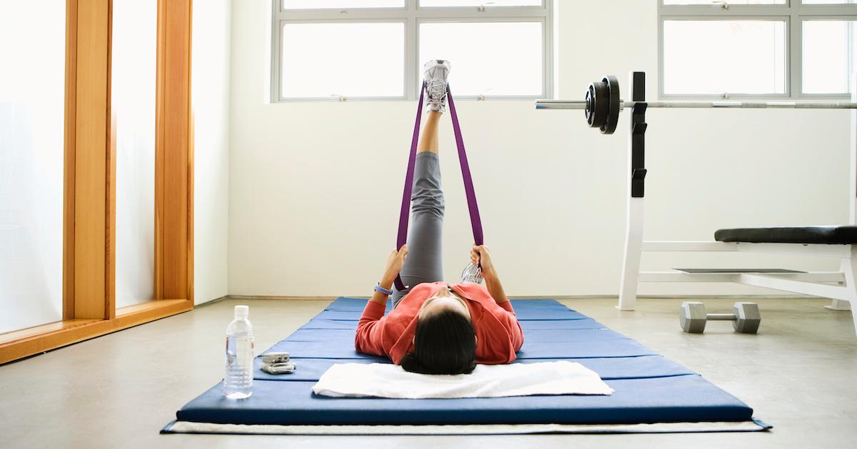 Someone stretching at the gym on their back.