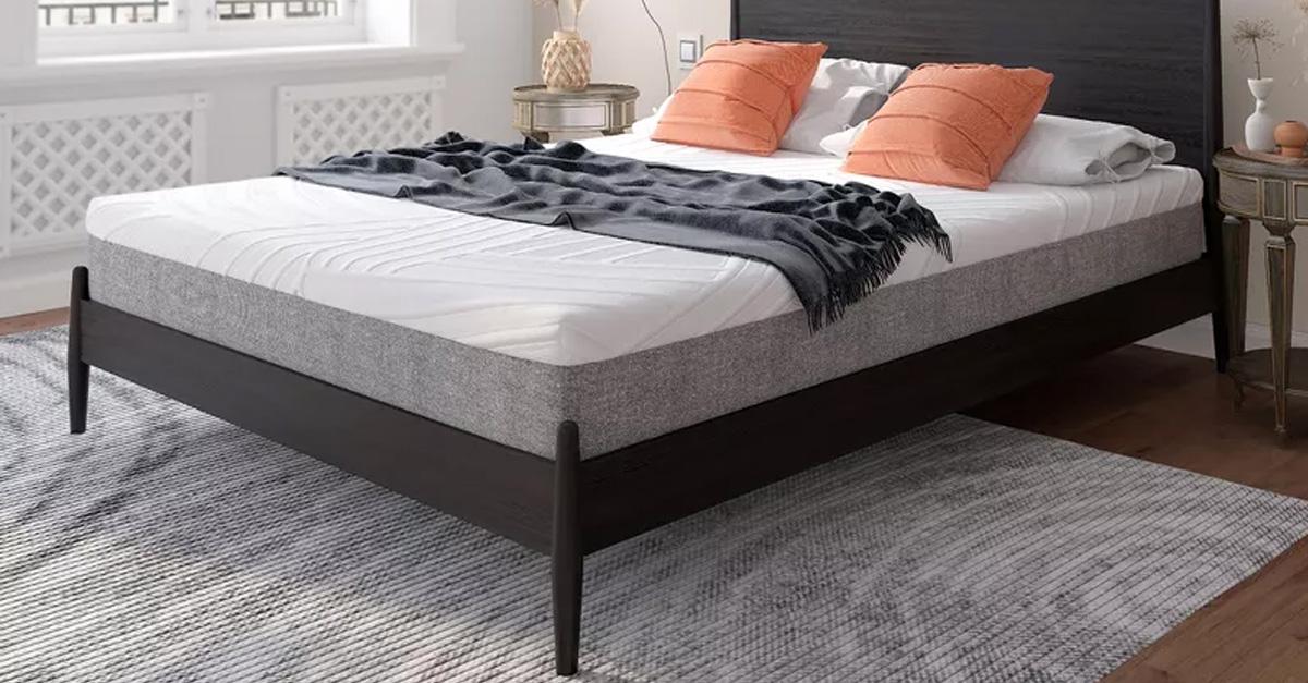 Mattress on platform bed with pillows, throw, and rug