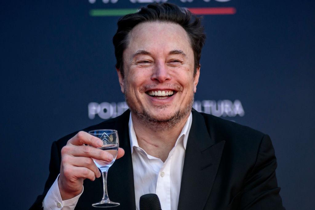 Elon Musk raises a glass of liquid before speaking at the Atreju political convention in December 2023 in Rome, Italy.