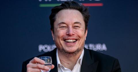 Elon Musk raises a glass of liquid before speaking at the Atreju political convention in December 2023 in Rome, Italy.