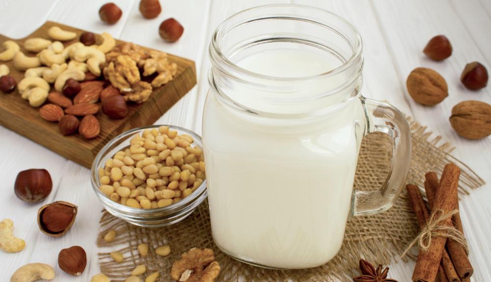 Various kinds of nuts with a jar of nut milk. 