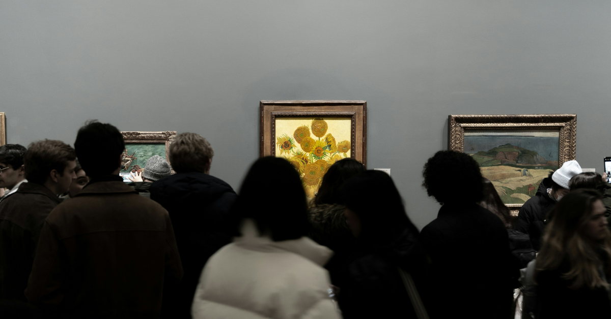 A crowd gathers in front of Vincent Van Gogh's painting of sunflowers