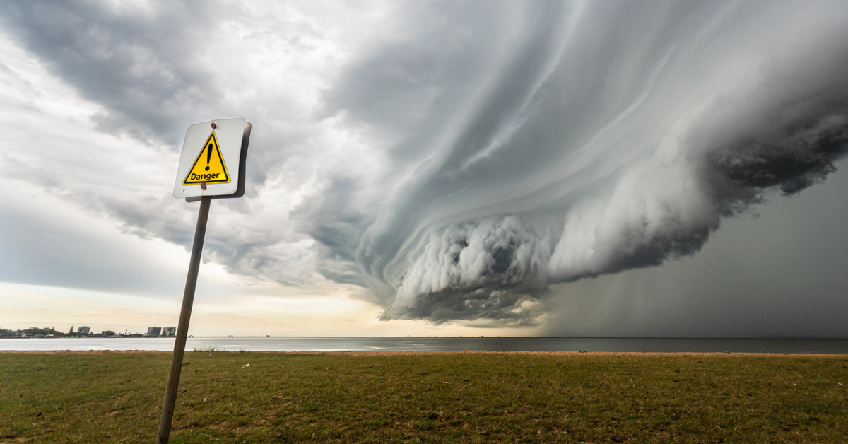 A storm forms over the water in the distance, pulling clouds into a circular formation