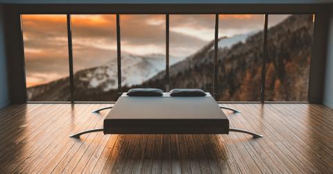 Bed in a room with a mountain view.