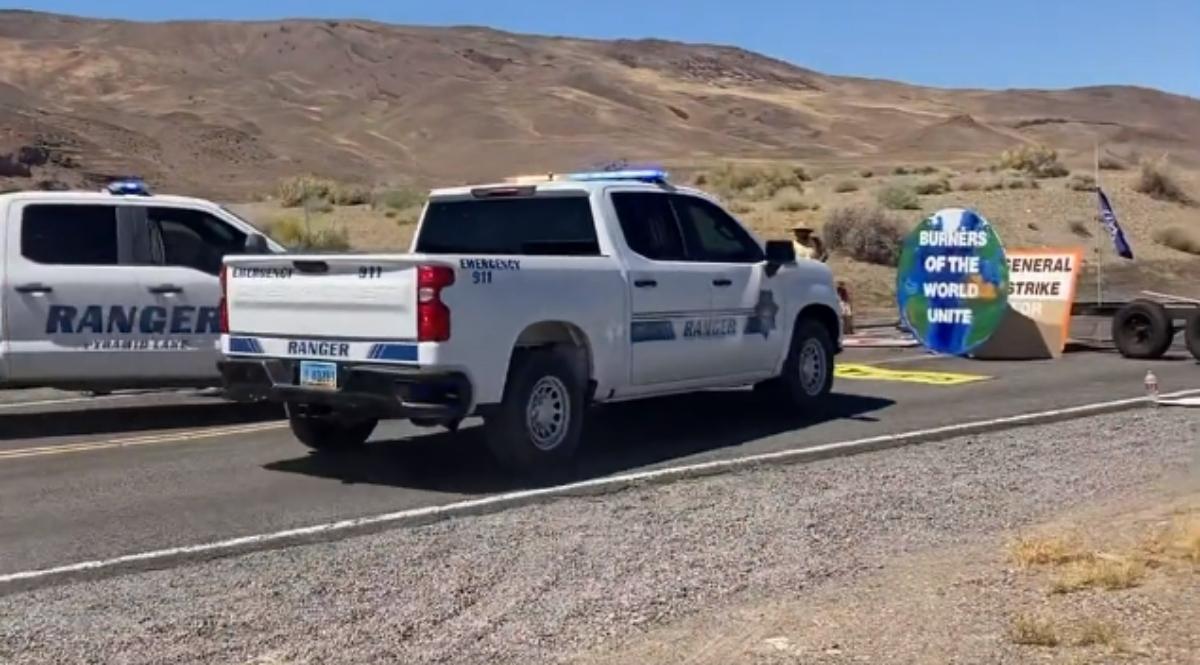 Ranger truck drives toward climate protest sign