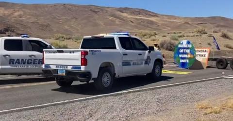 Ranger truck drives toward climate protest sign