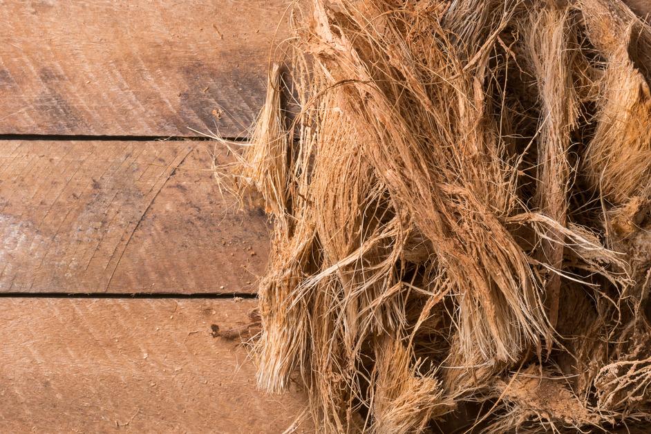 Coconut husk fiber laying on wooden paneling. 