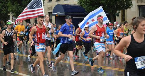 Runners carry flags while taking part in the Chicago Marathon