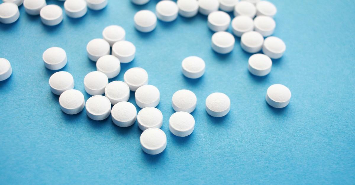 White pills sit on a blue background
