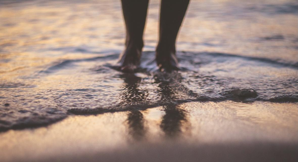 persons feet in beach water