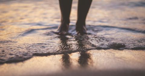 persons feet in beach water