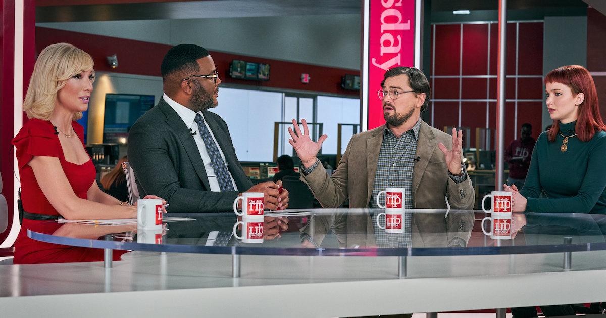 A still from 'Don't Look Up' featuring Cate Blanchett as Brie Evantee, Tyler Perry as Jack Bremmer, Leonardo DiCaprio as Dr. Randall Mindy, and Jennifer Lawrence as Kate Dibiasky, sitting at a TV news desk.