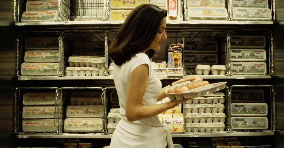 Woman shopping in egg aisle at the grocery store.