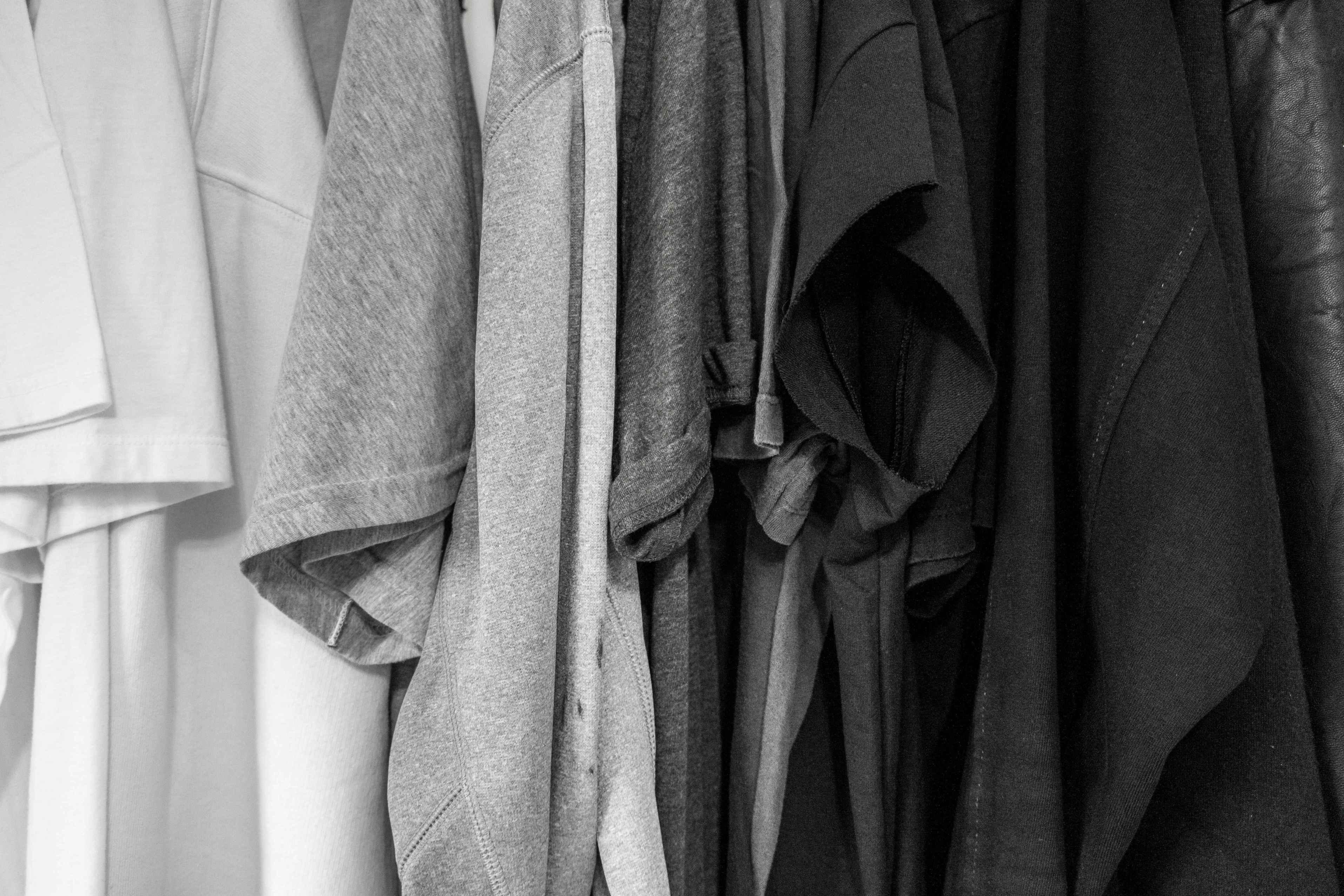 A series of shirts are pictured ordered by colors from white to gray to charcoal to black.