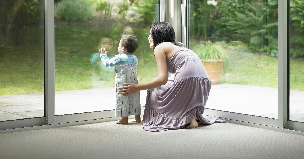 Parent and child looking out the window.