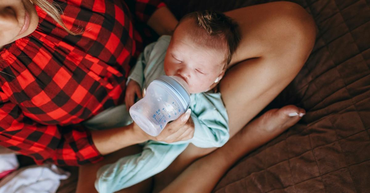 A new mom feeds her newborn with a baby bottle