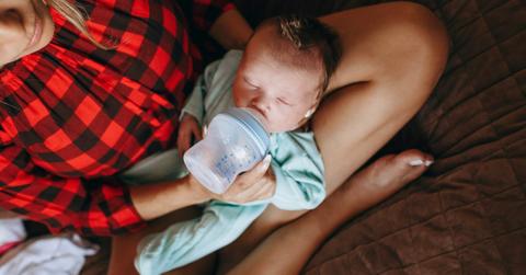 A new mom feeds her newborn with a baby bottle