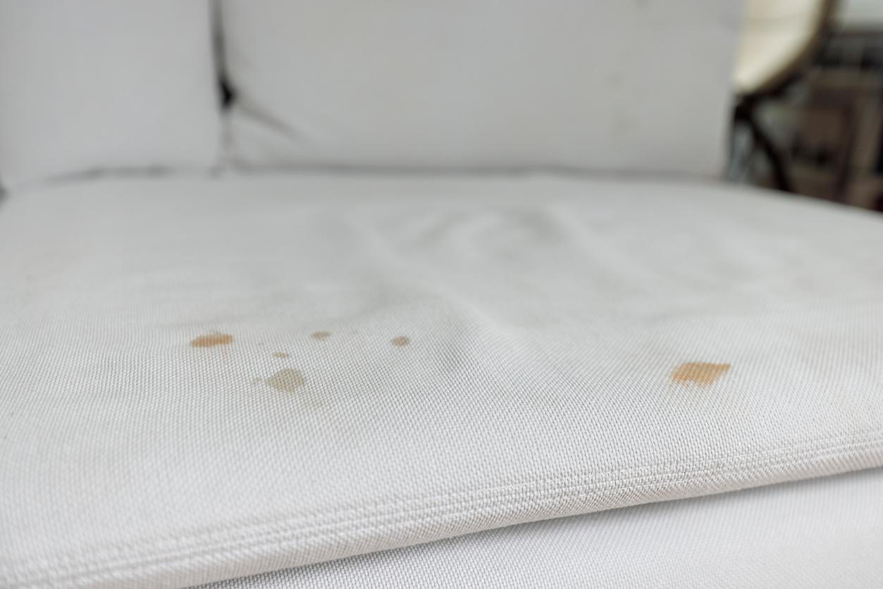 Close view of stains on a white microfiber couch.