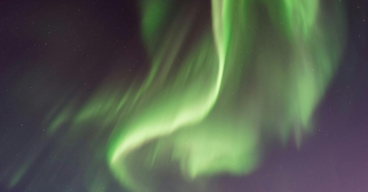 Green aurora borealis in the night sky. 