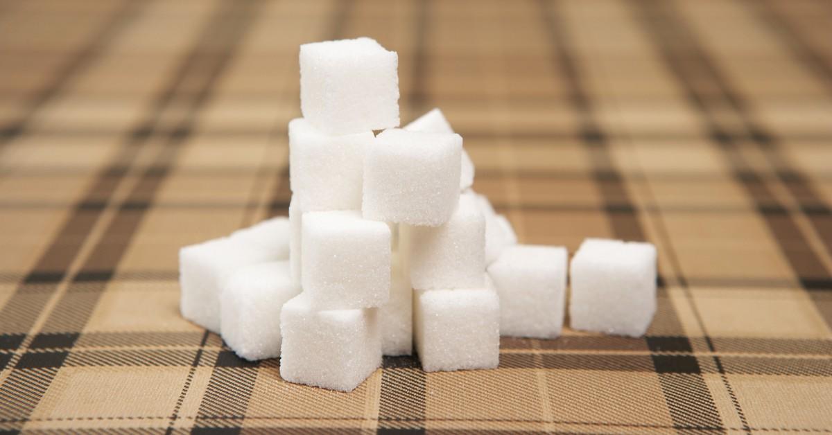 Closeup of sugar cubes and a plaid tablecloth 