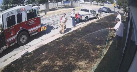 fire truck and people with hoses putting out lawn fire