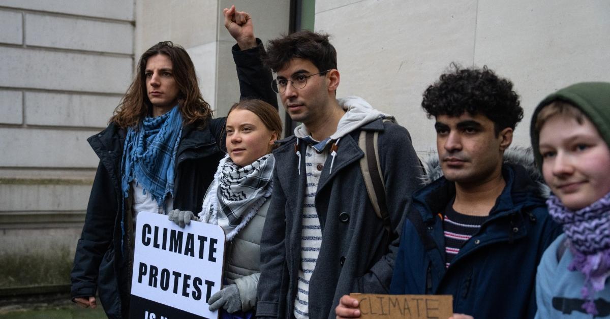 Greta Thunberg and other young climate activists protesting while holding up signs. 