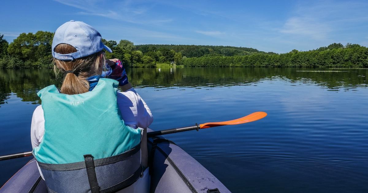 Back of woman kayaking by the Radunia river during hot summer day in Juszkowo, Poland on July 9, 2023.