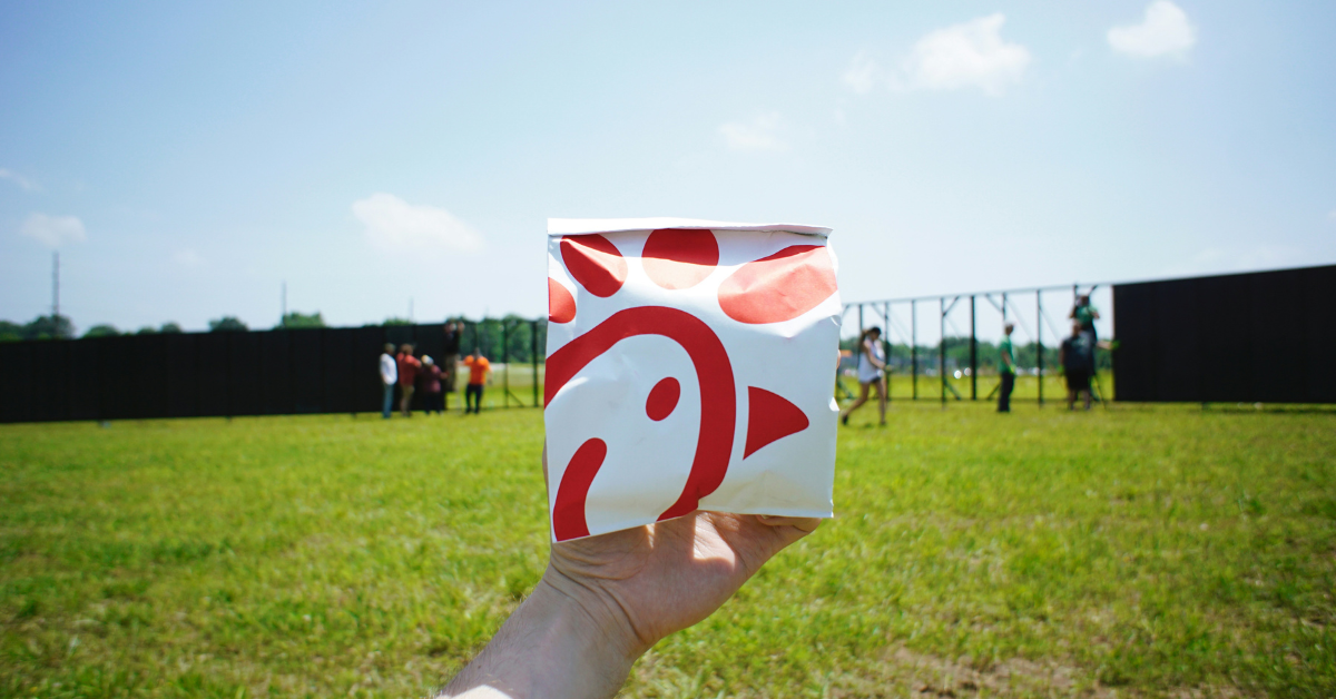 A person holds a Chick-fil-A bag featuring the company's logo