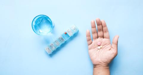 Person holding pills in hand to take.