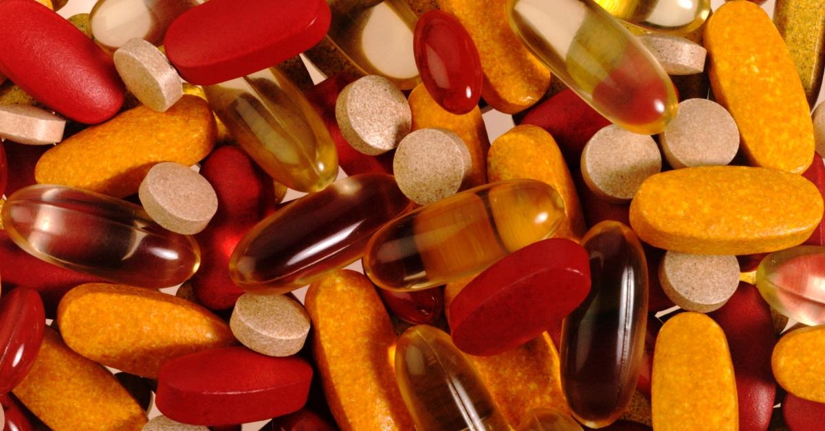 Pile of orange and red vitamin supplements.