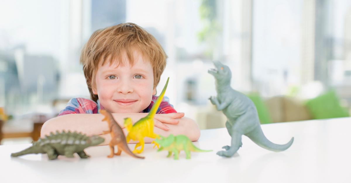 Child playing with plastic dinosaur toys