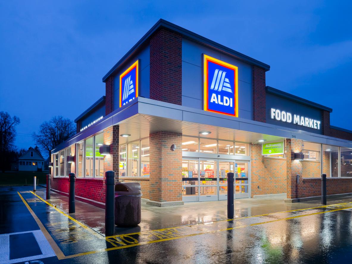 An Aldi supermarket is pictured at night with a wet parking lot.