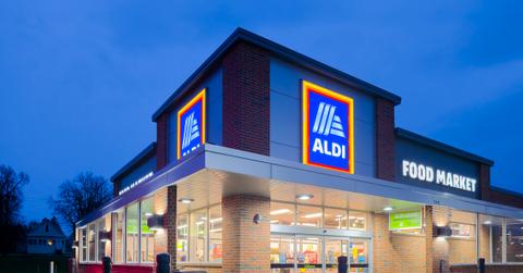 An Aldi supermarket is pictured at night with a wet parking lot.