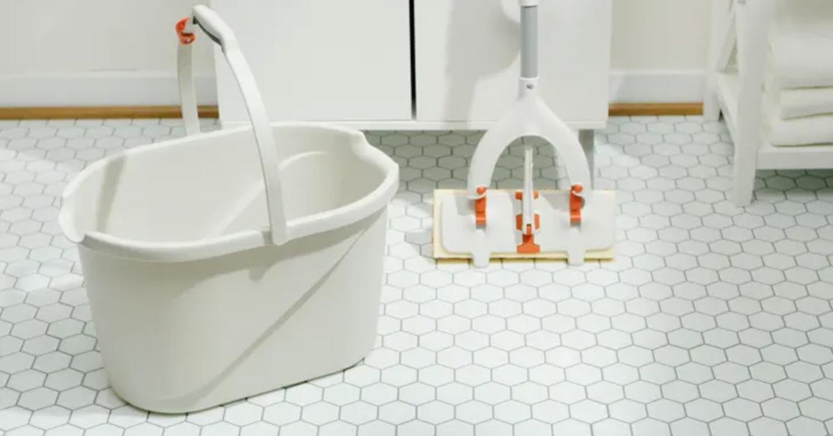 white mop and bucket in white tiled bathroom