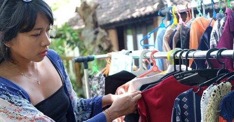 Stock photo of woman thrifting at outdoor flea market.