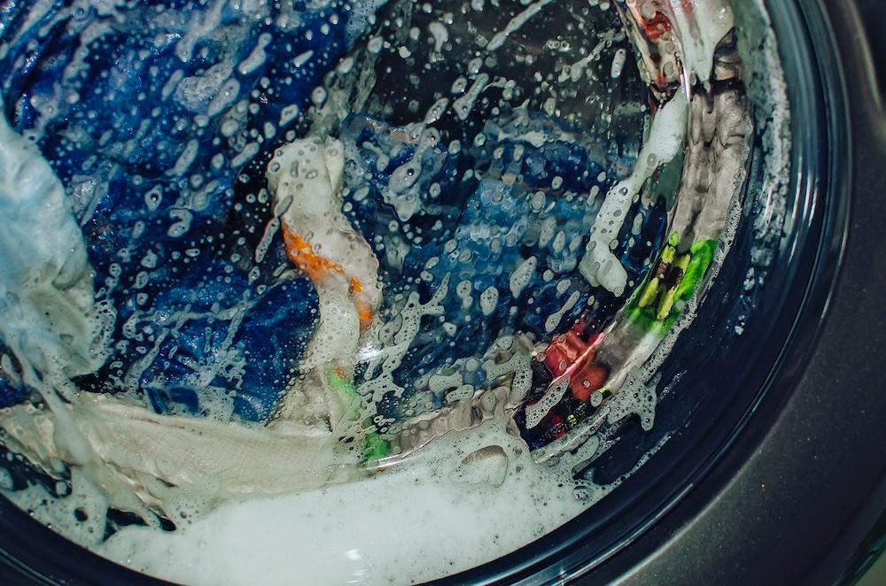 A closeup of clothing in a washing machine in the middle of a cycle. 