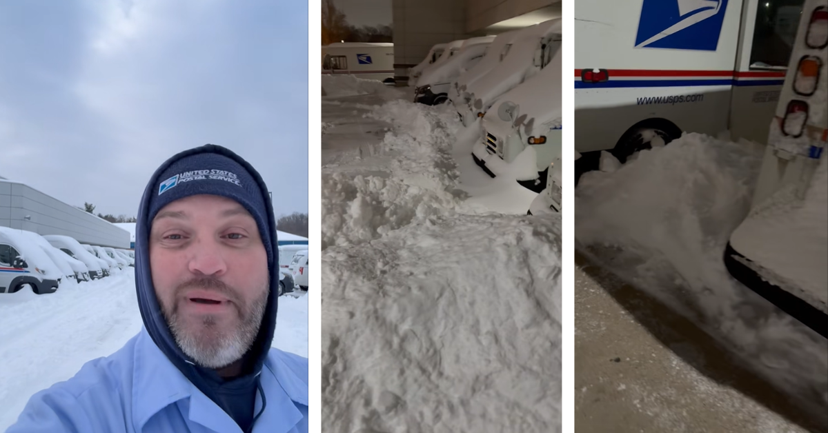 A mail carrier shows how much snow is near his mail trucks