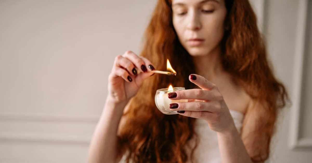 A woman lighting a candle. (Representative Image Source: Pexels | Yan Krukau)
