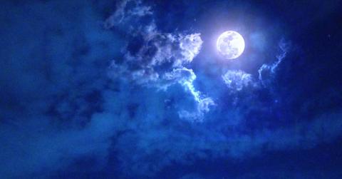 Magnificent moon scape with magical clouds around the moon all in hues of blue