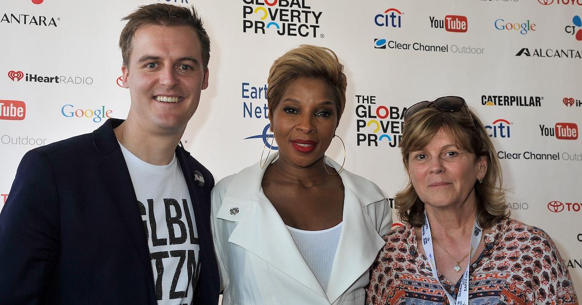 Hugh Evans, Mary J. Blige, and Kathleen Rogers smile at the camera