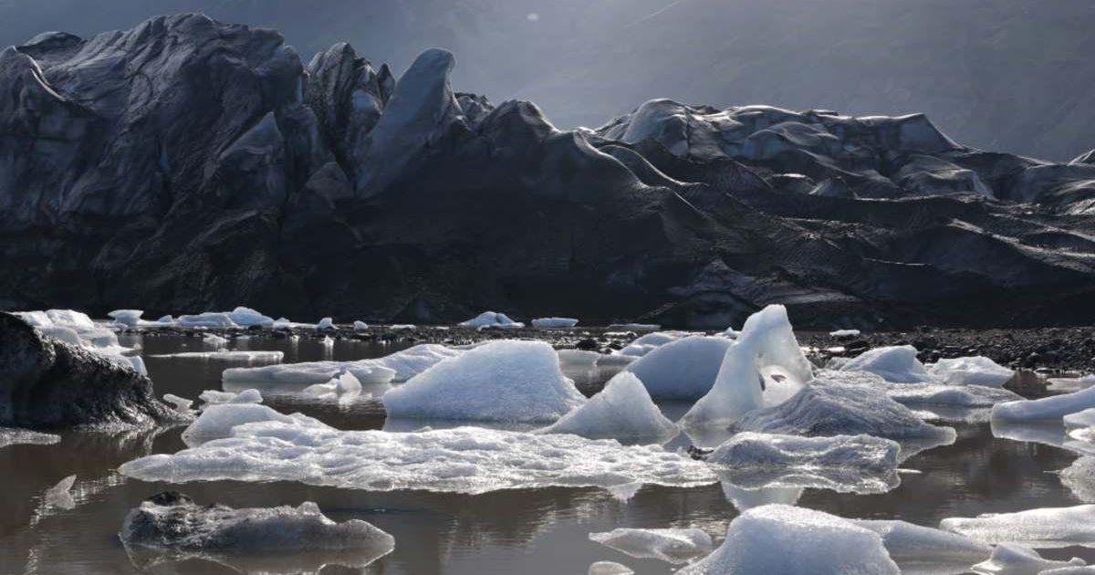Melting ice from Svinafellsjokull glacier floats in a lake of meltwater as the glacier, a portion of it blackened by volcanic rock and dust, looms behind, near Svinafell, Iceland. (Cover Image Source: Getty Images | Sean Gallup)