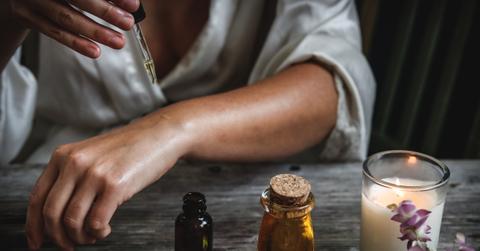 woman applying essential oil with dropper