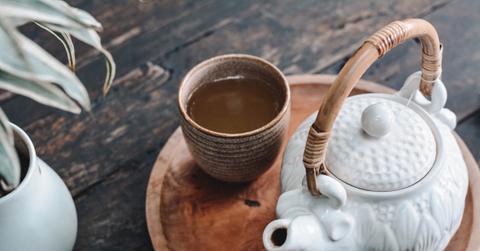 A teapot next to a mug of tea