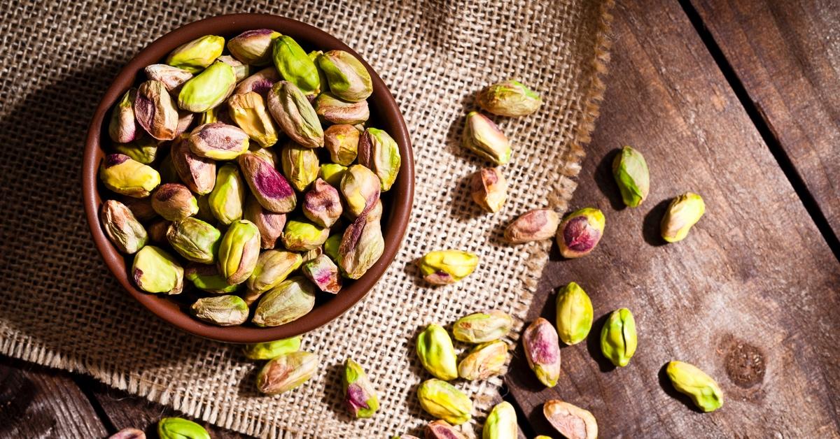 Shelled pistachios in a bowl on a table. 